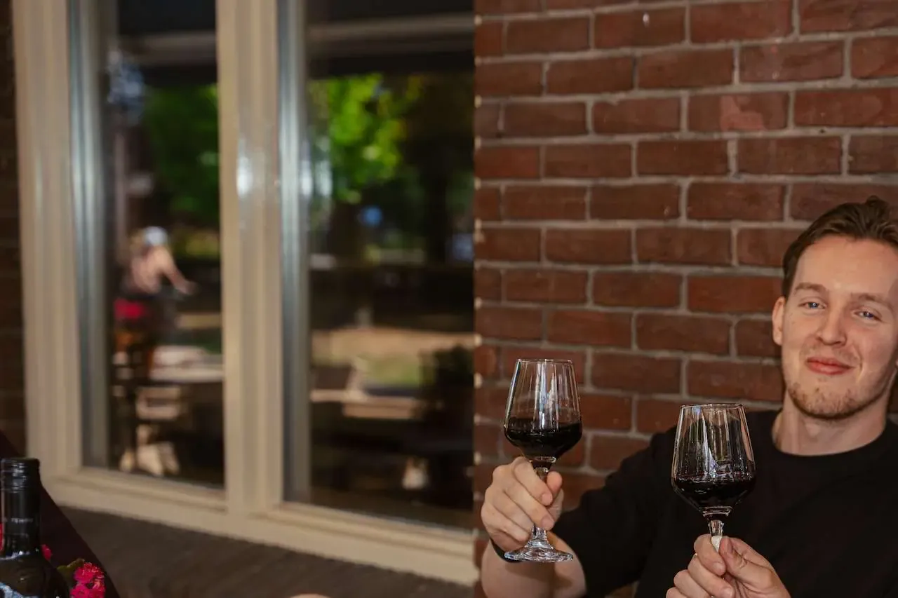 2 vrienden die proosten met rode wijn